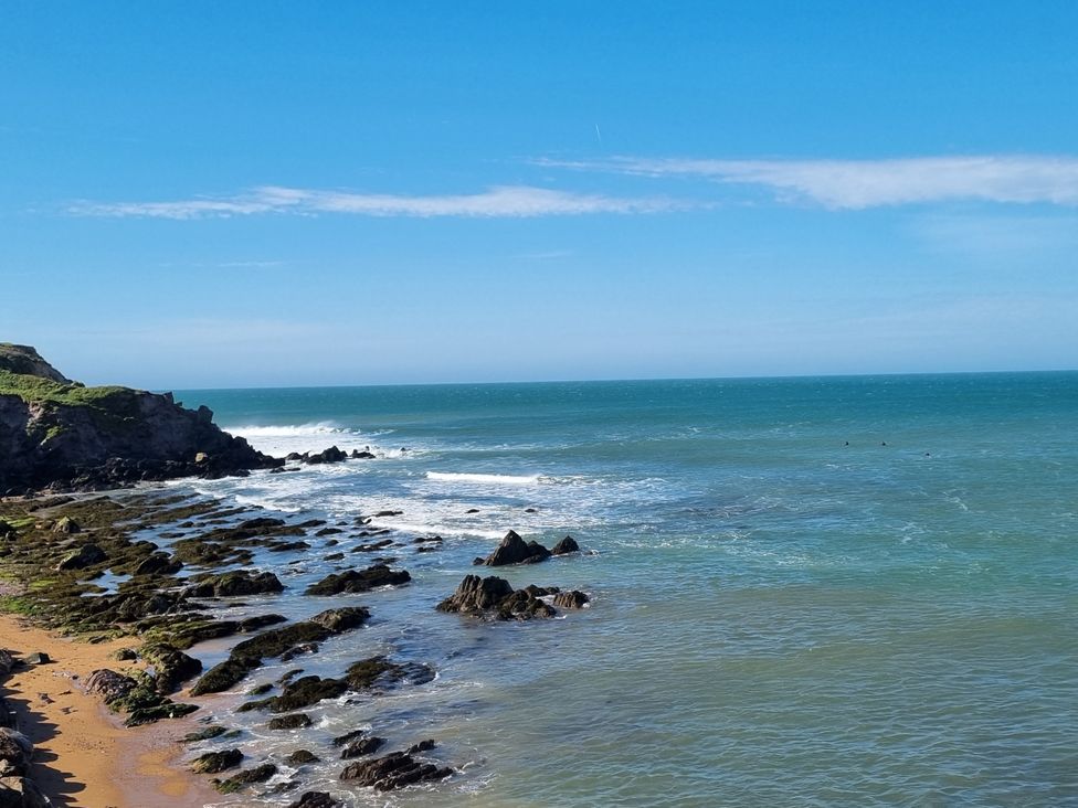 A beach with rocks and waves at Sea View Beach Apartment Thurlestone