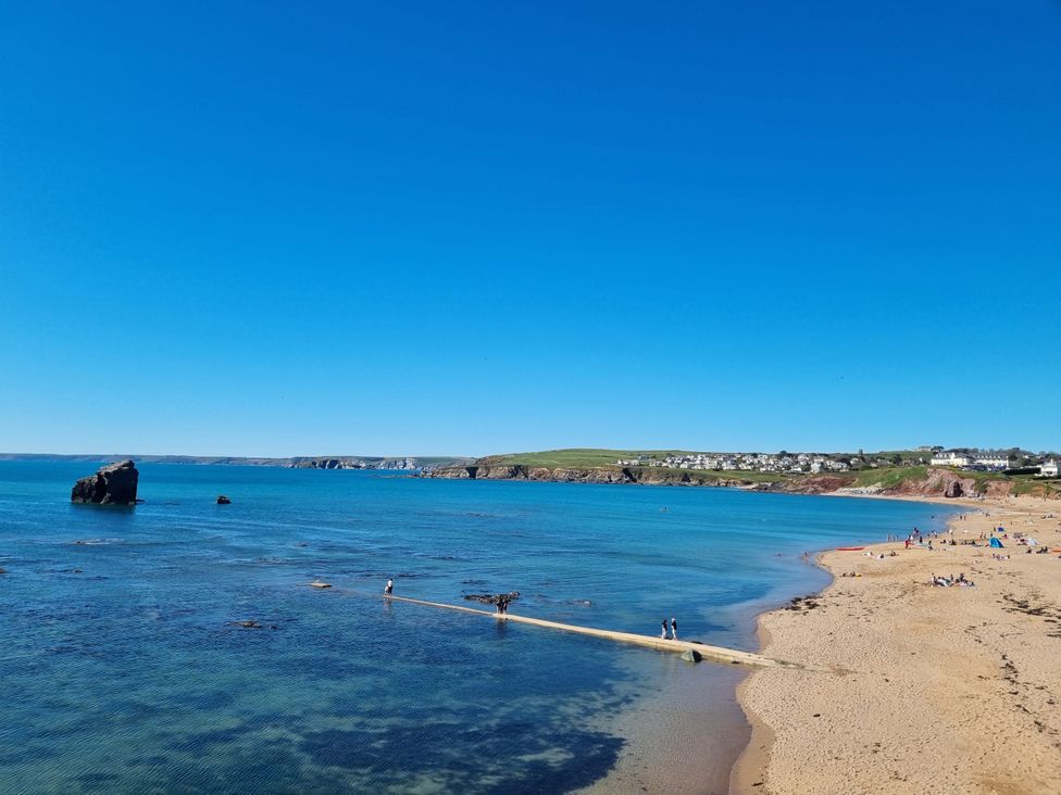 A beach with a boardwalk and people at Sea View Beach Apartment in Thurlestone