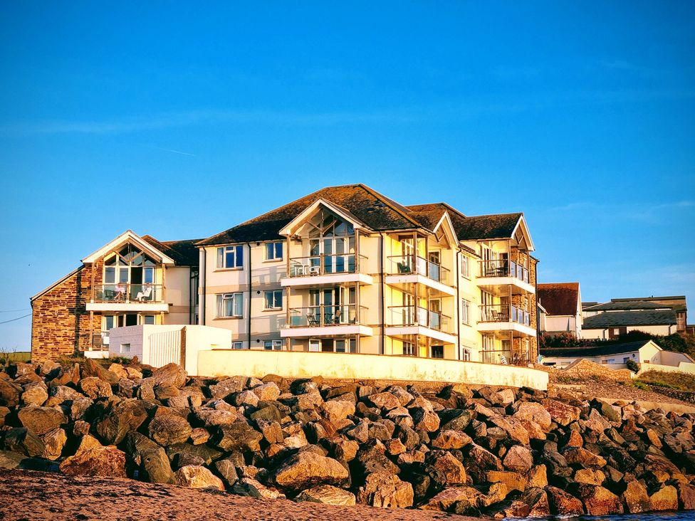A building with balconies and a rock formation at Sea View Beach Apartment Thurlestone