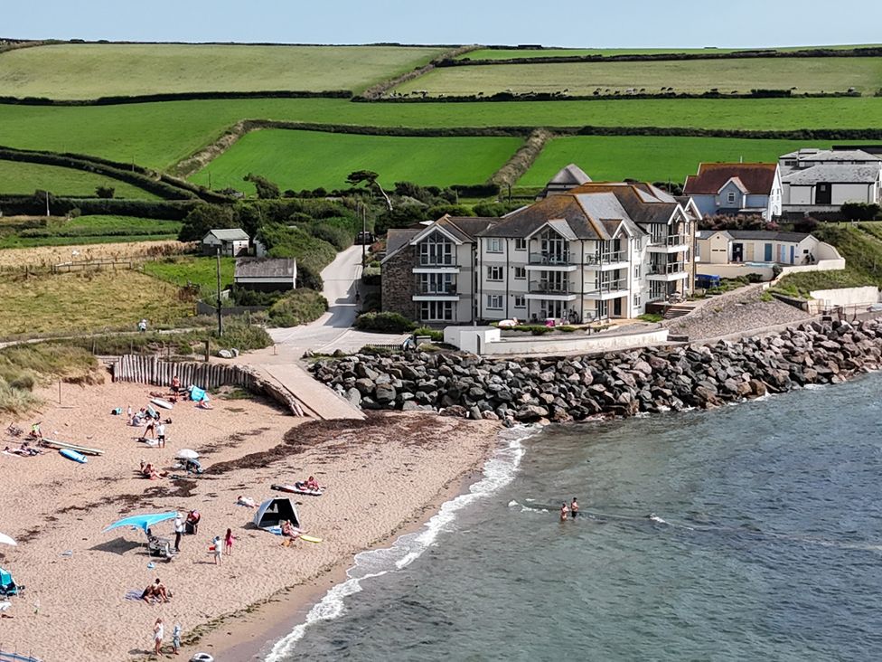 A beach with people sunbathing and swimming at Sea View Beach Apartment in Thurlestone