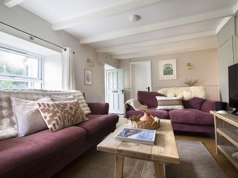 A living room with couches and a coffee table at Rock View in Trethurgy near St Austell