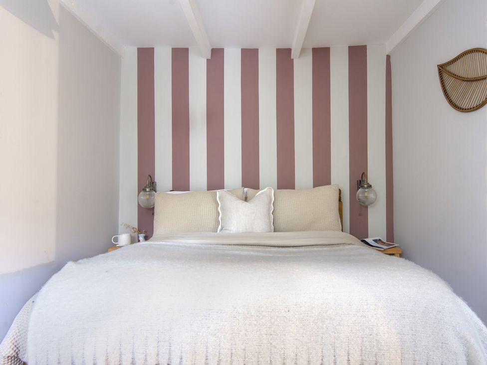 A bedroom with a bed and striped walls at Rock View Trethurgy near St Austell