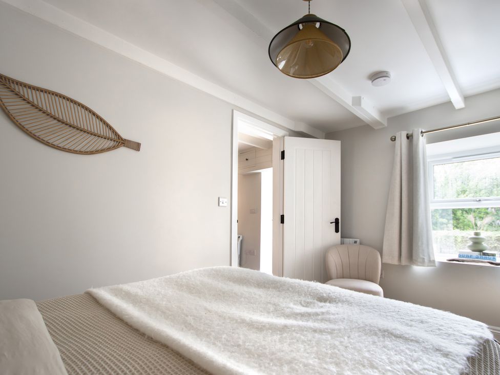 A bedroom with a bed and a window at Rock View in Trethurgy near St Austell