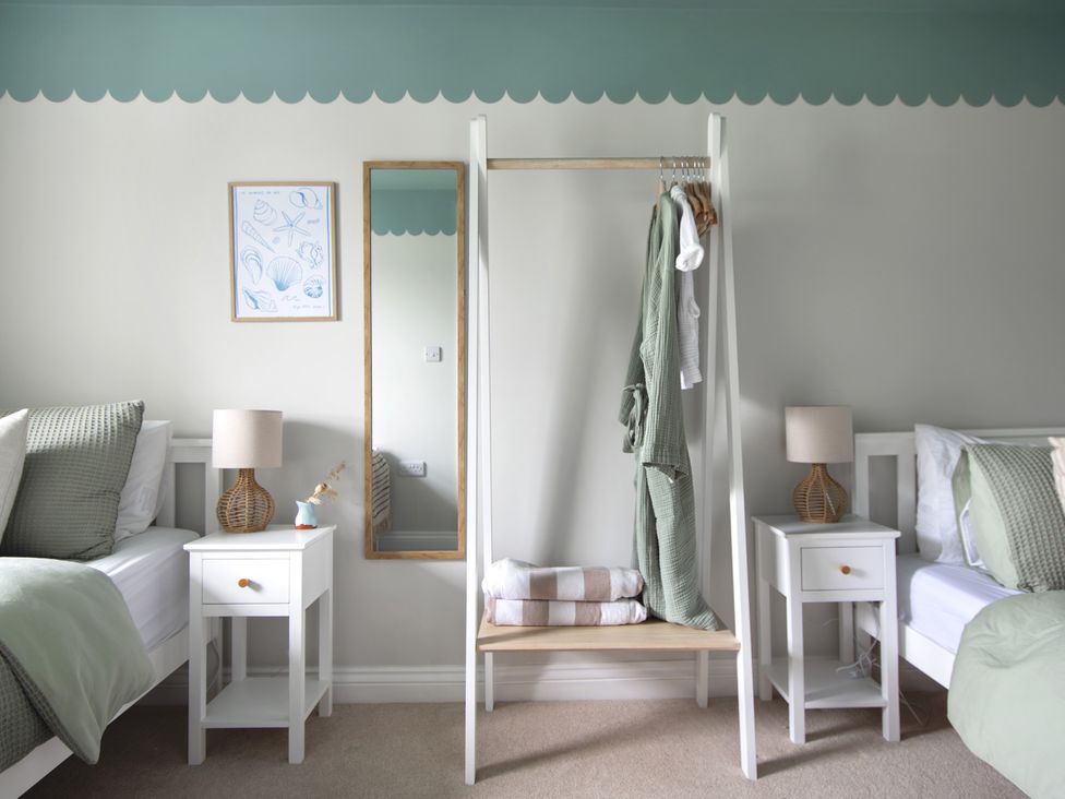 A bedroom with two beds and a hanging rack at Rock View near Trethurgy near St Austell