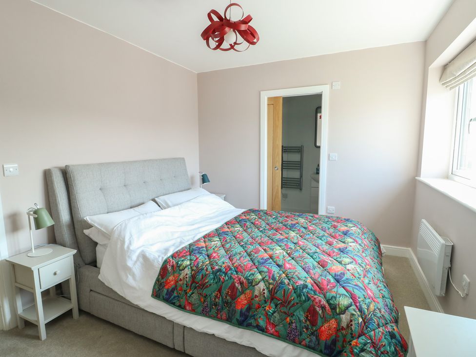 A bedroom with a bed and bedside table at 36 Parc Delfryn