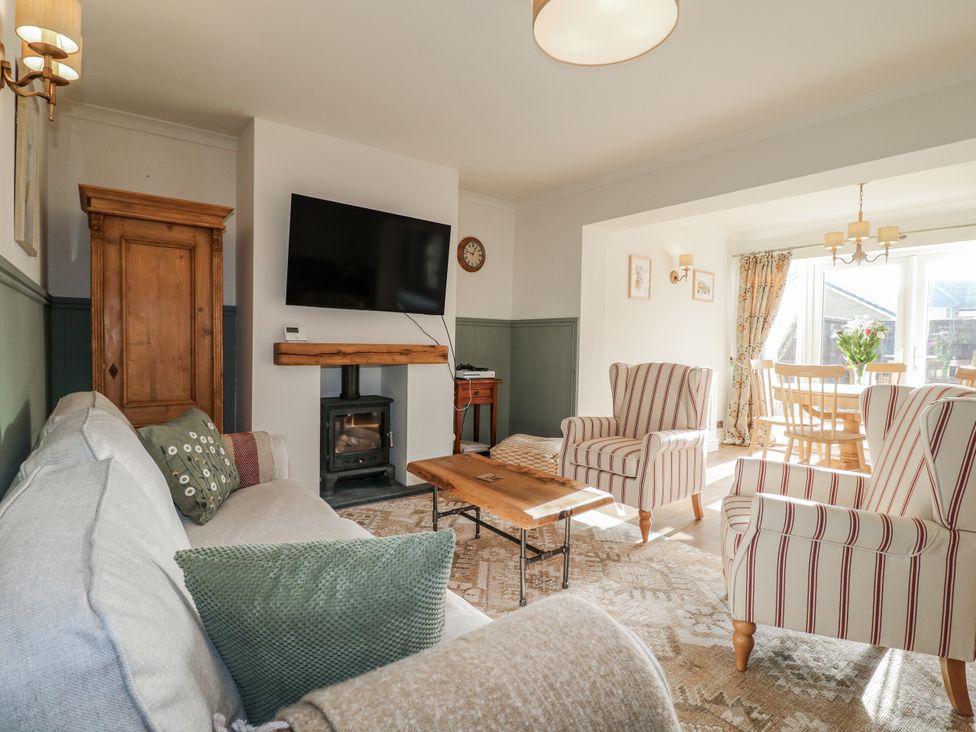 A living room with a sofa, armchairs, and television at 6 Pine Walk Uttoxeter
