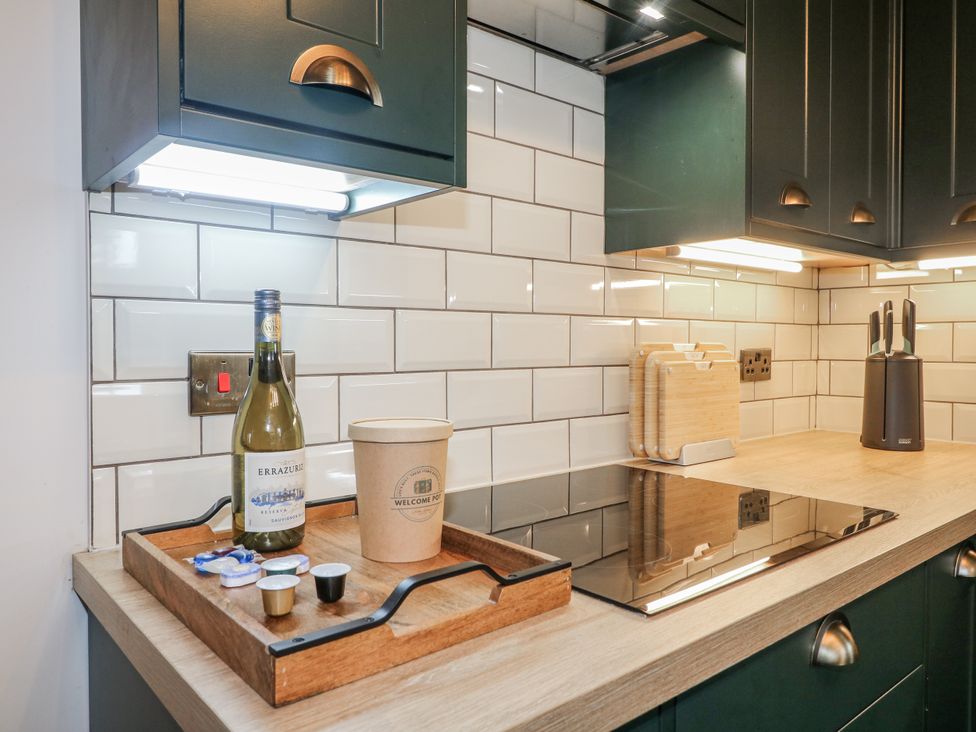 A kitchen with a wine bottle and coffee pods on a tray at 6 Pine Walk in Uttoxeter