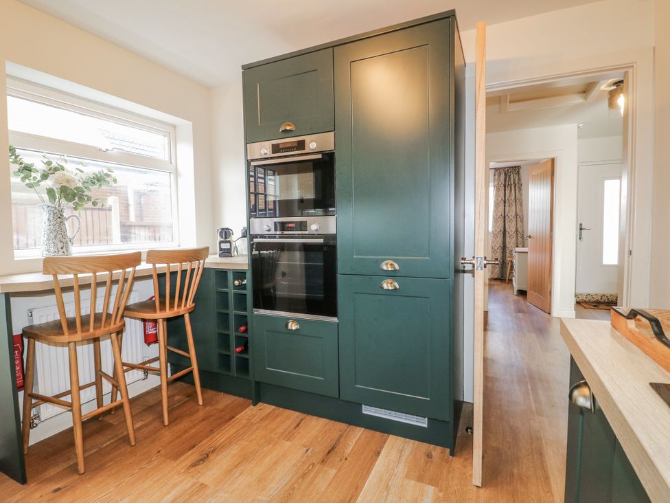 A kitchen with two stools and an oven at 6 Pine Walk Uttoxeter