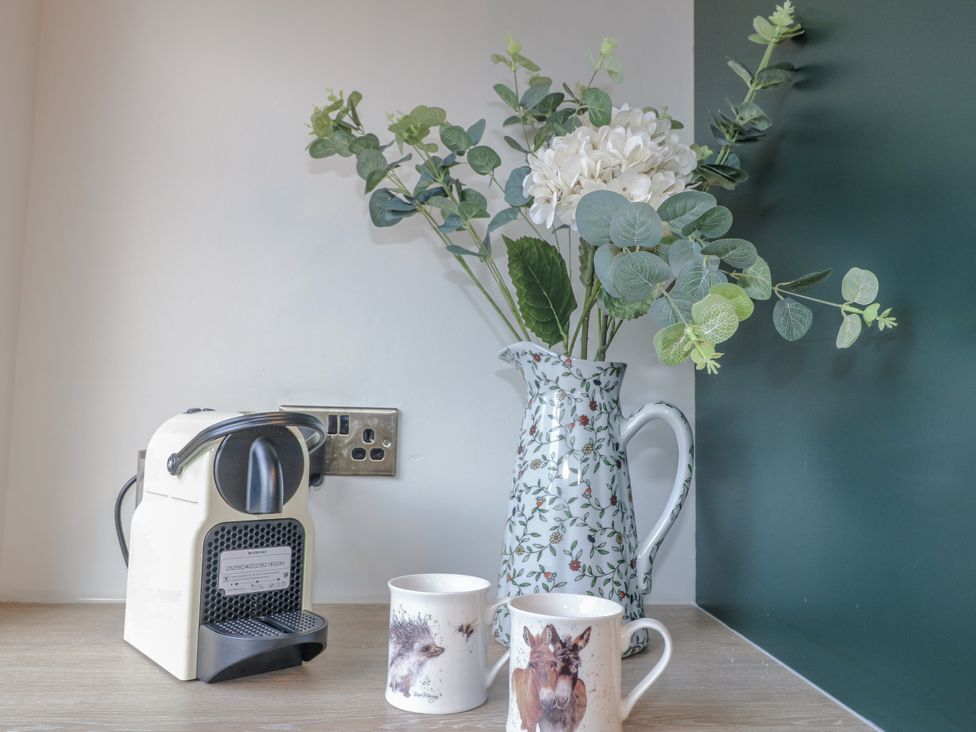 A coffee machine with mugs and a flower pitcher at 6 Pine Walk in Uttoxeter