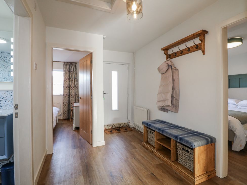 A hallway with a coat rack and bench at 6 Pine Walk in Uttoxeter