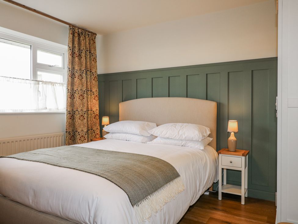 A bedroom with a bed and curtains at 6 Pine Walk in Uttoxeter