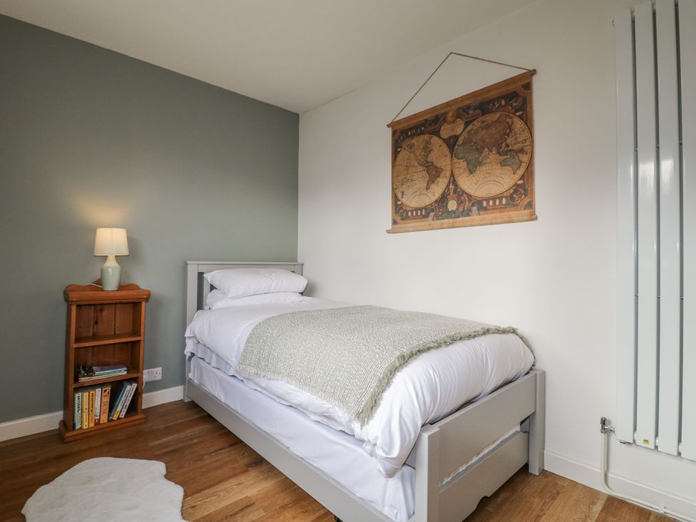 A bedroom with a bed and a bookshelf at 6 Pine Walk in Uttoxeter