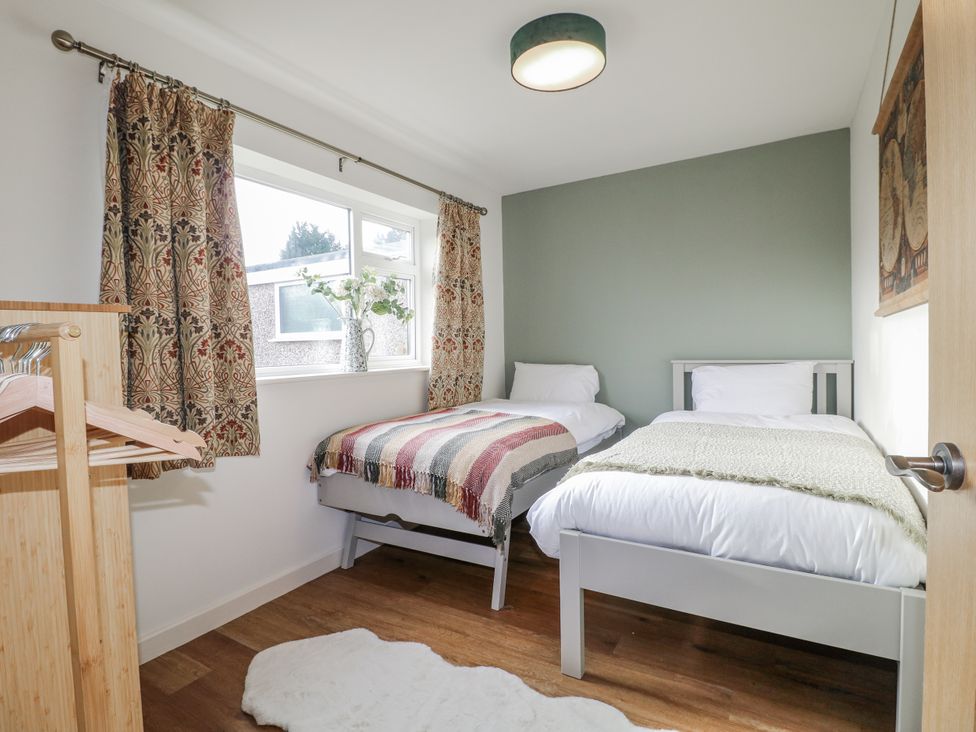 A bedroom with two beds and a window at 6 Pine Walk Uttoxeter