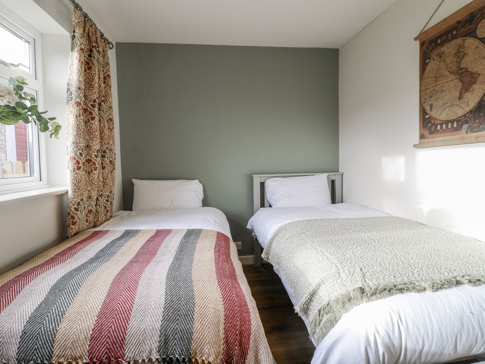 A bedroom with two beds and a window at 6 Pine Walk in Uttoxeter