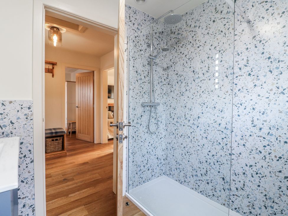 A bathroom with a shower and door at 6 Pine Walk Uttoxeter