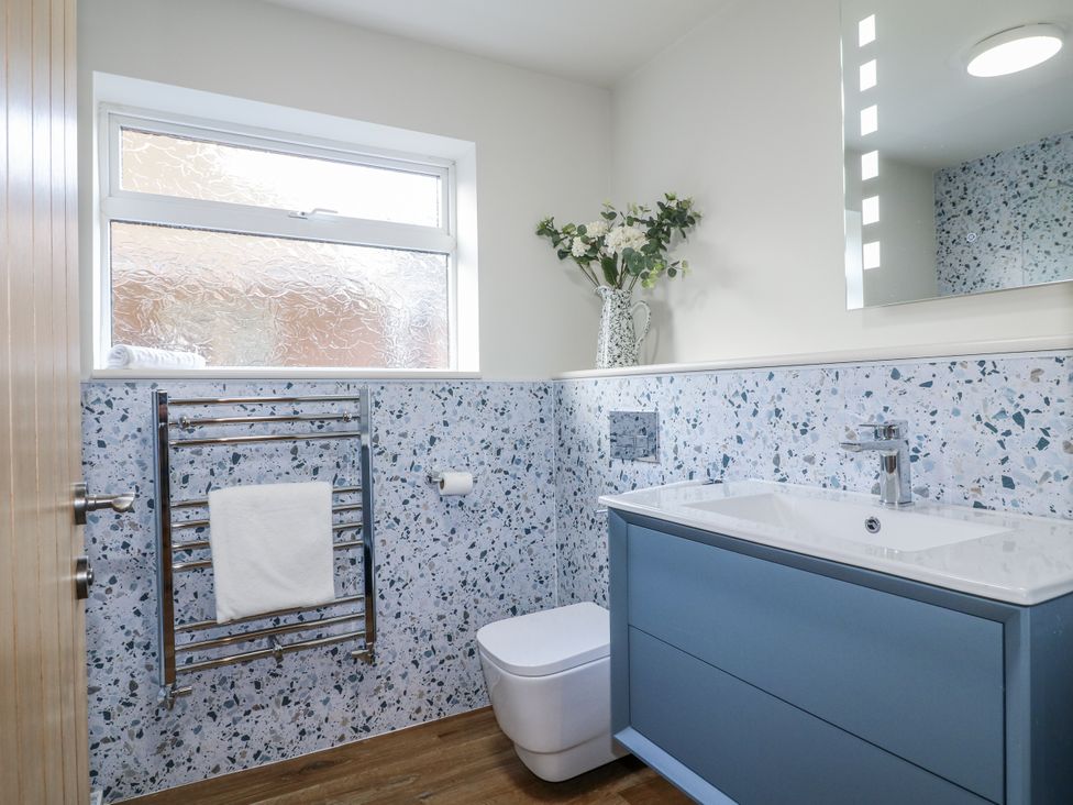 A bathroom with a sink, toilet and towel rack at 6 Pine Walk in Uttoxeter