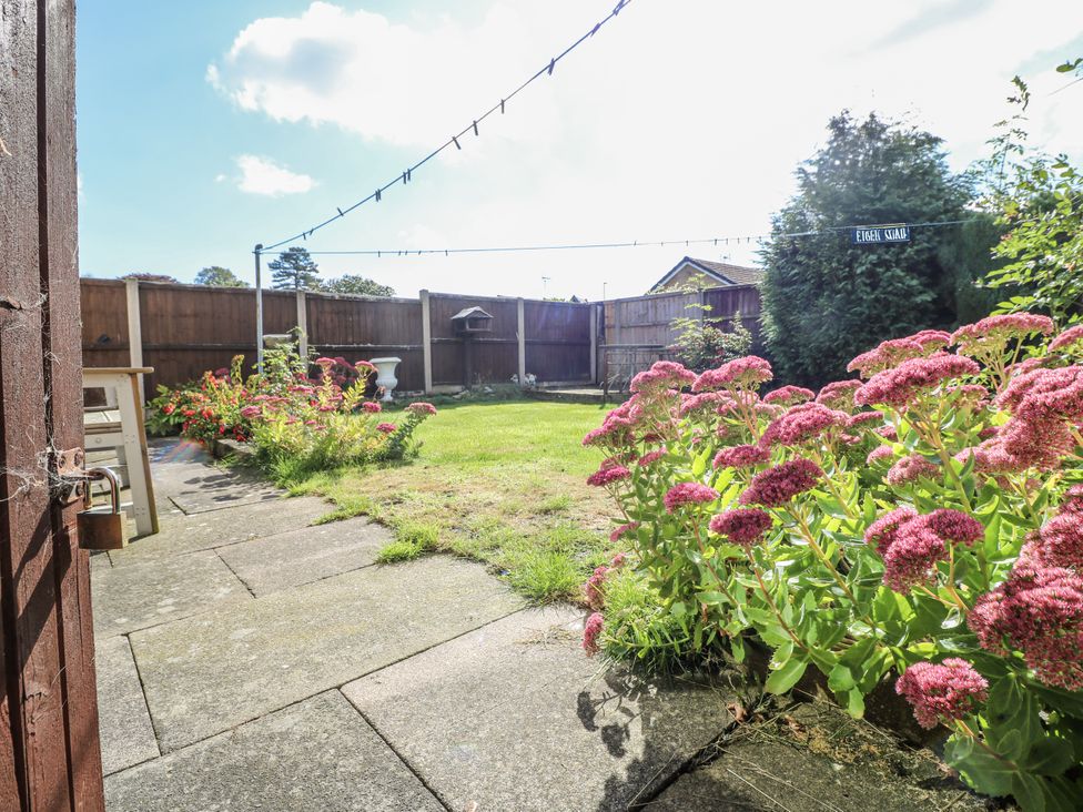 A garden with flowers and grass at 6 Pine Walk in Uttoxeter