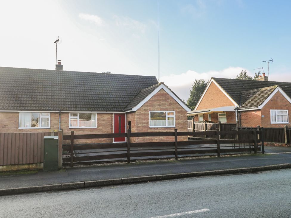 A bungalow with a front porch and fence at 6 Pine Walk in Uttoxeter