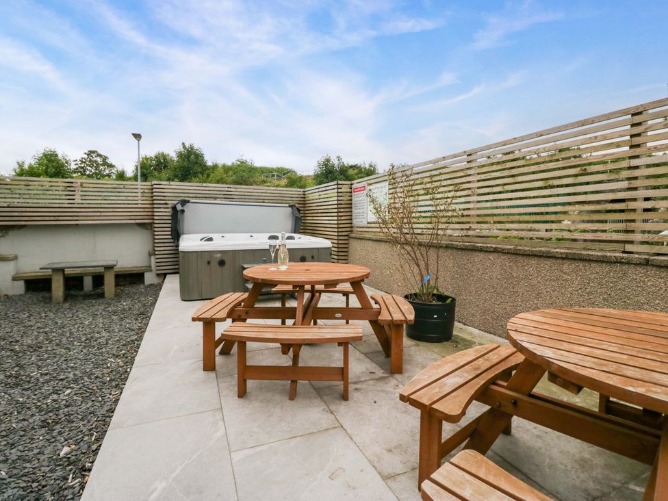 An outdoor area with a hot tub and table at Lund House Ulverston