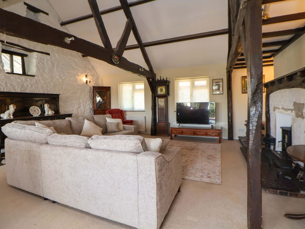 A living room with a sofa and television at The Old Barn in Pentre Celyn