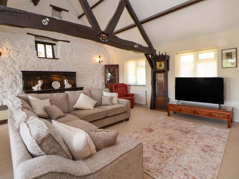 A living room with a sofa and television at The Old Barn in Pentre Celyn