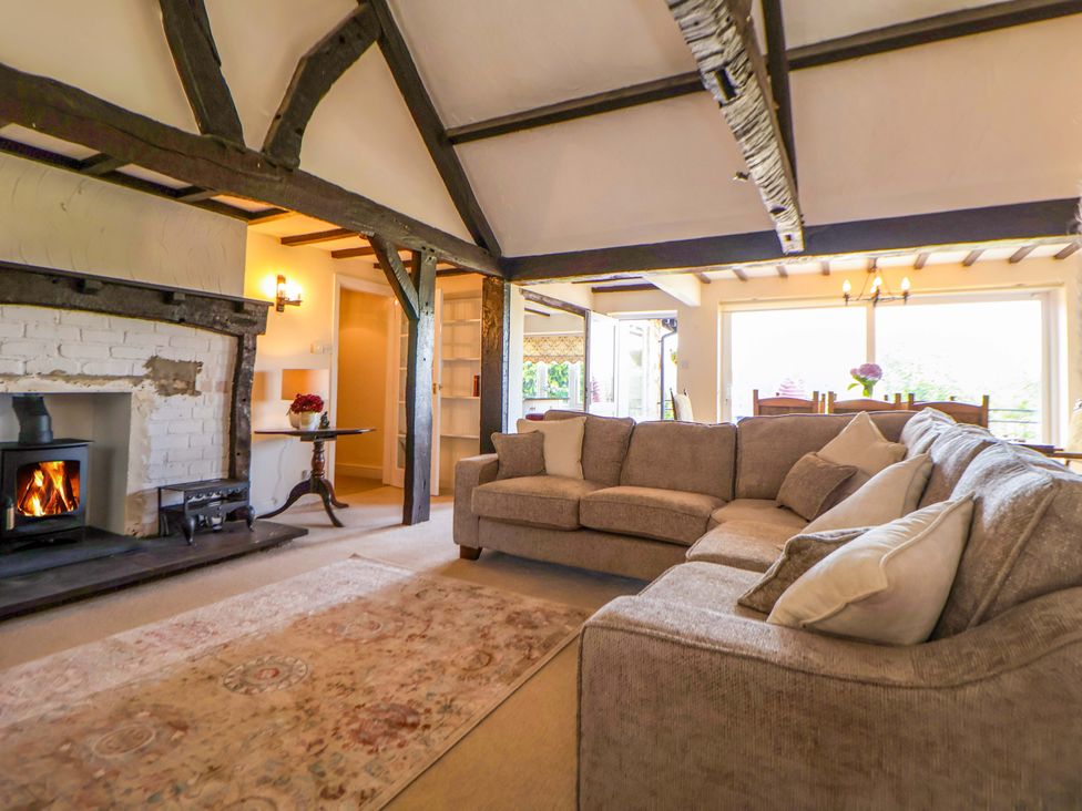 A living room with a sofa and fireplace at The Old Barn in Pentre Celyn