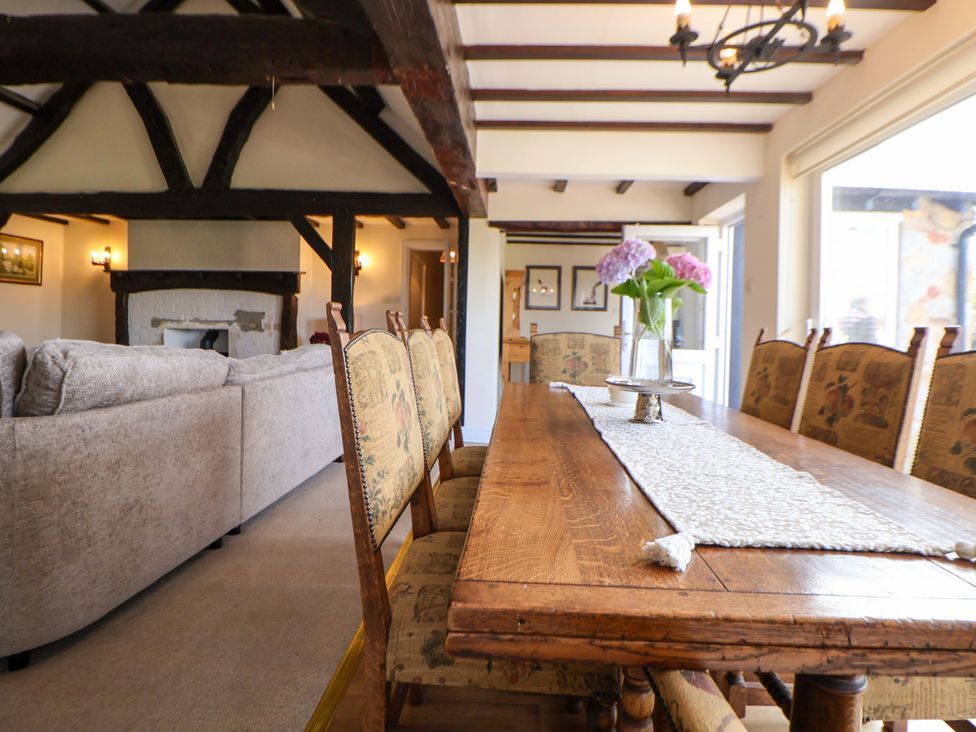 A dining room with a wooden table and chairs at The Old Barn in Pentre Celyn