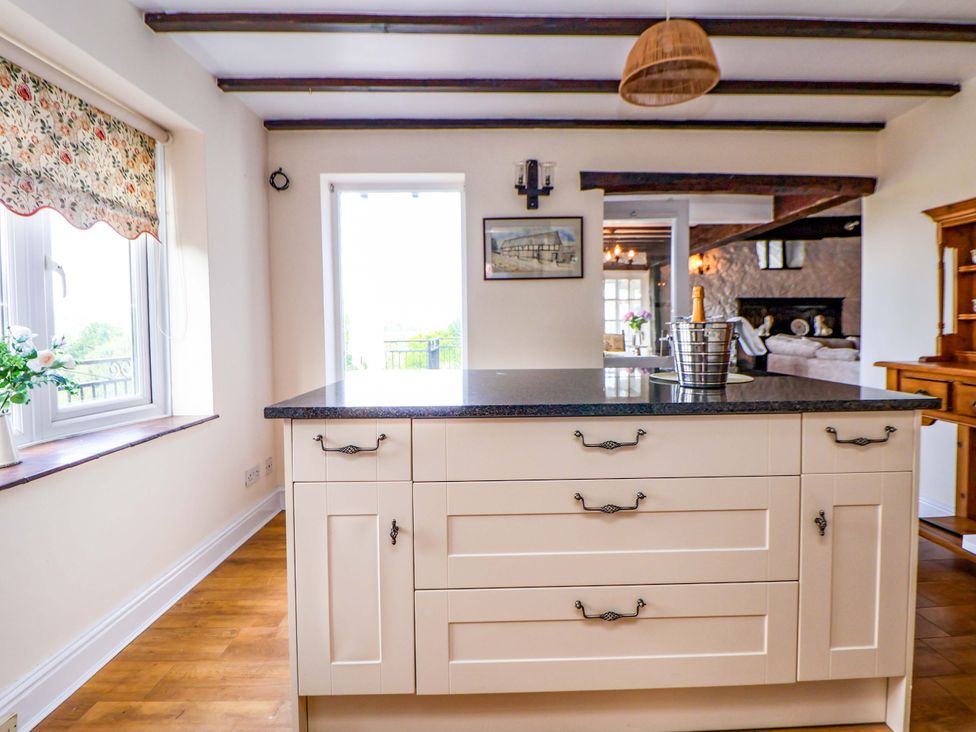 A kitchen with an island and window at The Old Barn in Pentre Celyn