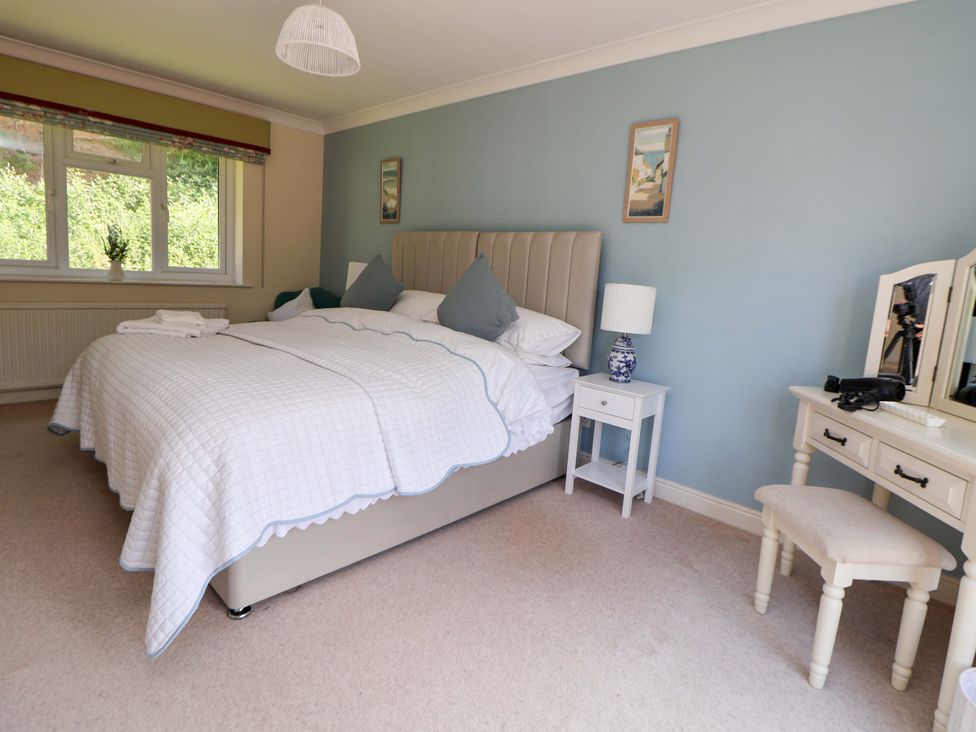 A bedroom with a bed and dressing table at The Old Barn in Pentre Celyn