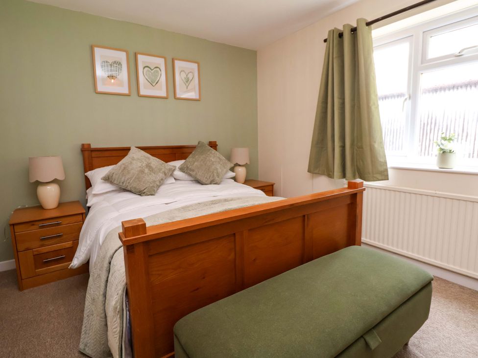 A bedroom with a bed and bedside tables at The Old Barn in Pentre Celyn