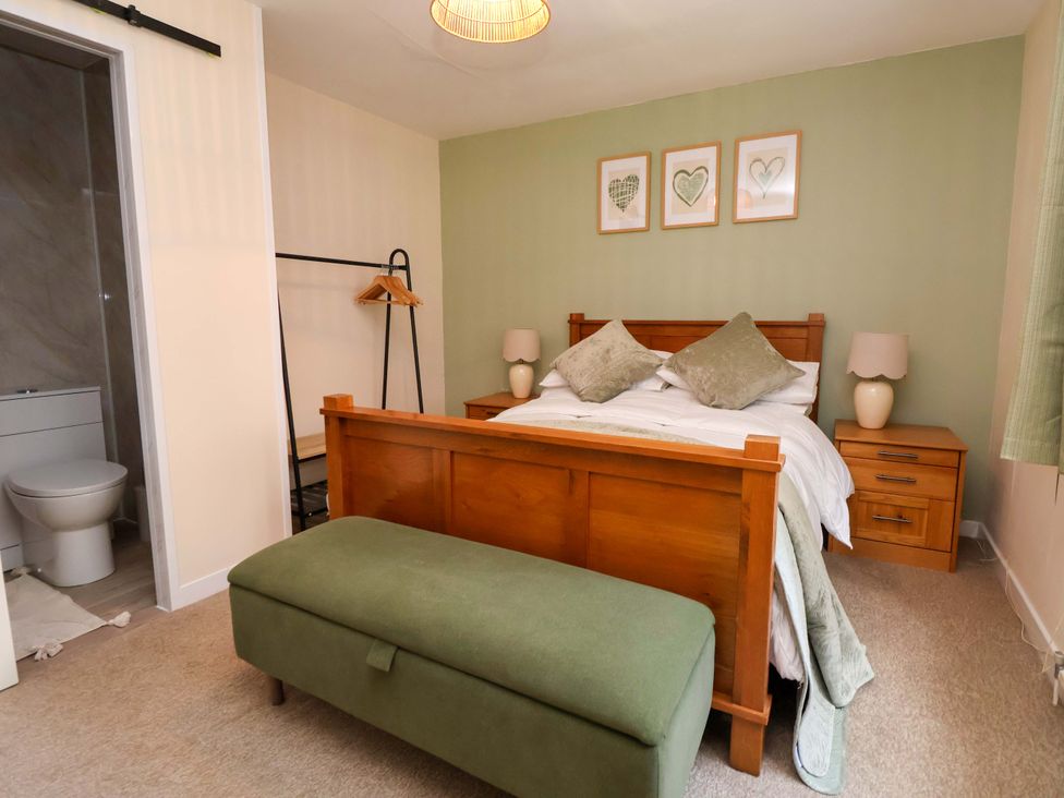A bedroom with a bed and nightstand at The Old Barn in Pentre Celyn