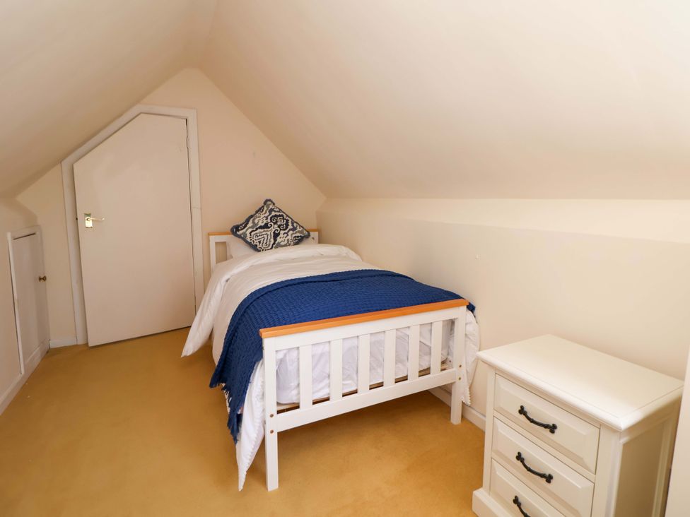 A bedroom with a bed and chest of drawers at The Old Barn in Pentre Celyn