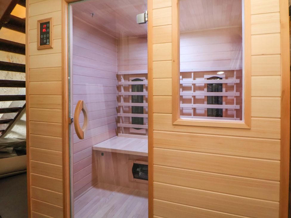 A sauna with a bench and control panel at The Old Barn in Pentre Celyn