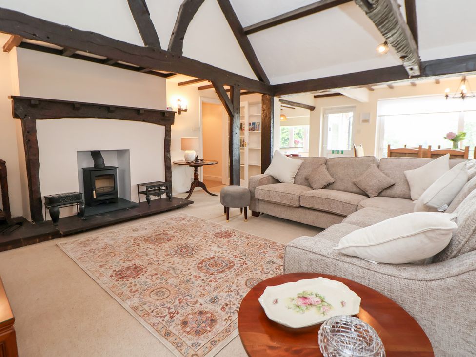 A living room with a sofa and fireplace at The Old Barn in Pentre Celyn