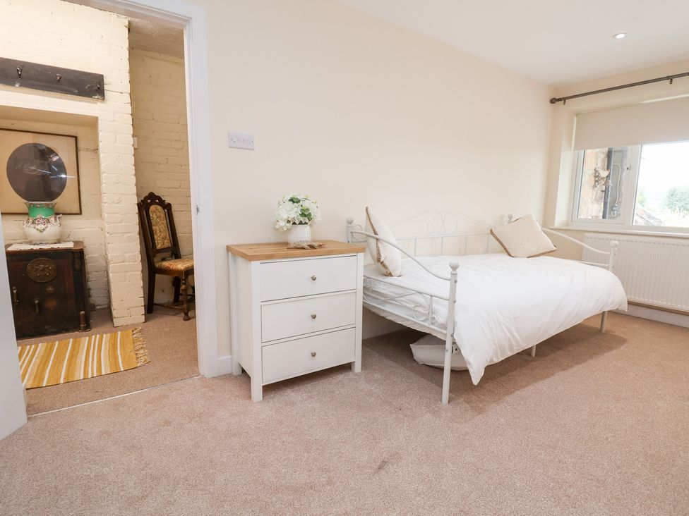 A bedroom with a bed and dresser at The Old Barn in Pentre Celyn