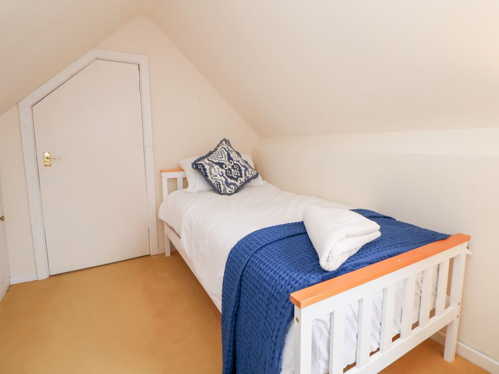 A bedroom with a bed and a door at The Old Barn in Pentre Celyn