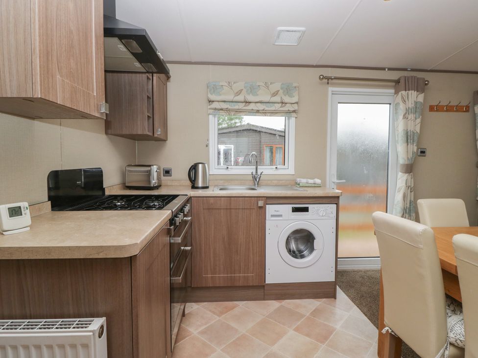 A kitchen with appliances and a dining table at Aspen in Denny
