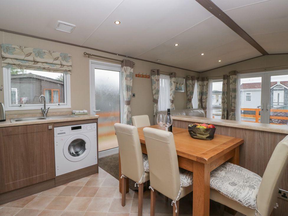 A kitchen with a dining table and washing machine at Aspen in Denny