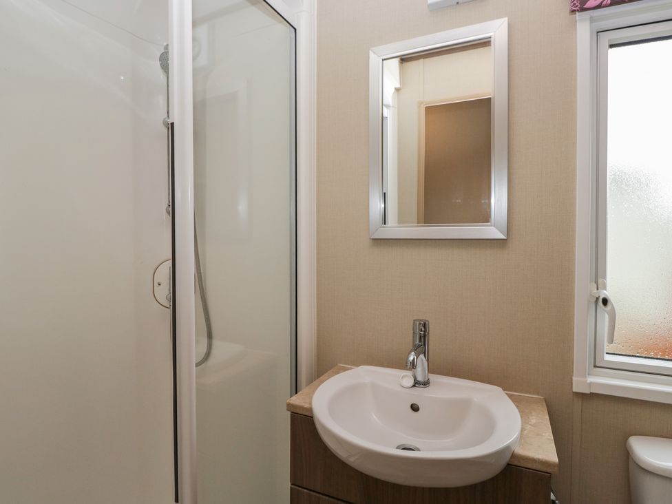 A bathroom with a shower and sink at Aspen in Denny