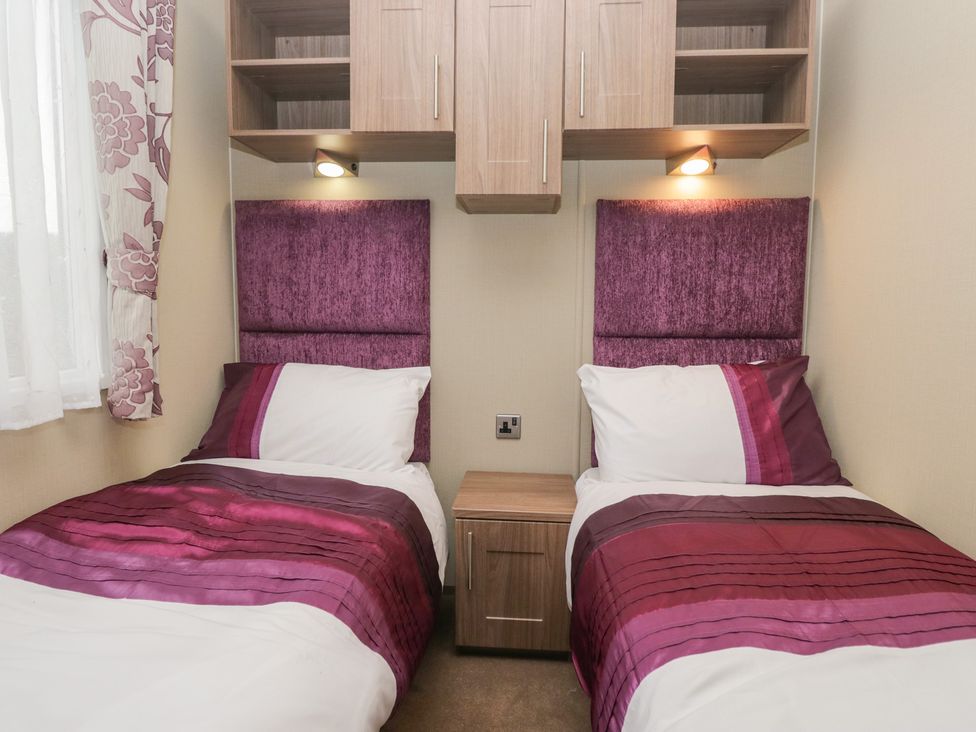A bedroom with two single beds and a nightstand at Aspen in Denny