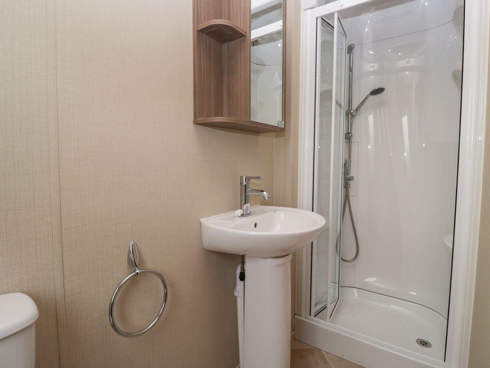 A bathroom with a shower, sink, and toilet at Aspen in Denny