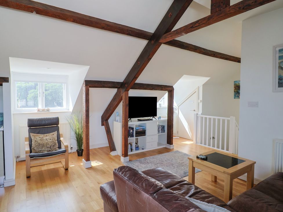 A living room with a television and a chair at Cliff View in Seaton