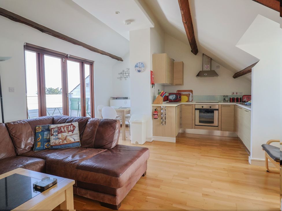 A living room with a sofa and kitchen area at Cliff View in Seaton