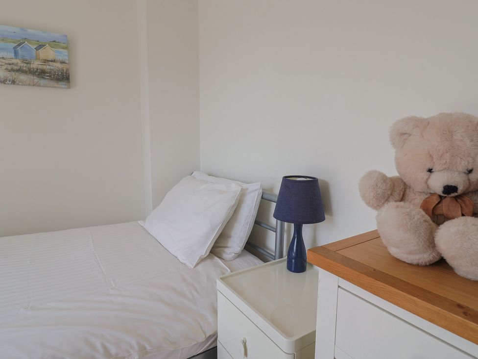 A bedroom with a bed and a teddy bear at Cliff View in Seaton
