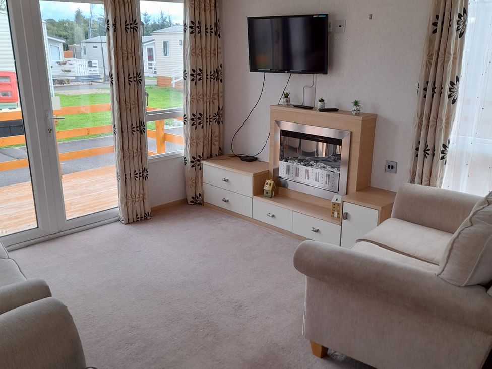 A living room with a television and sofa at Oak in Denny