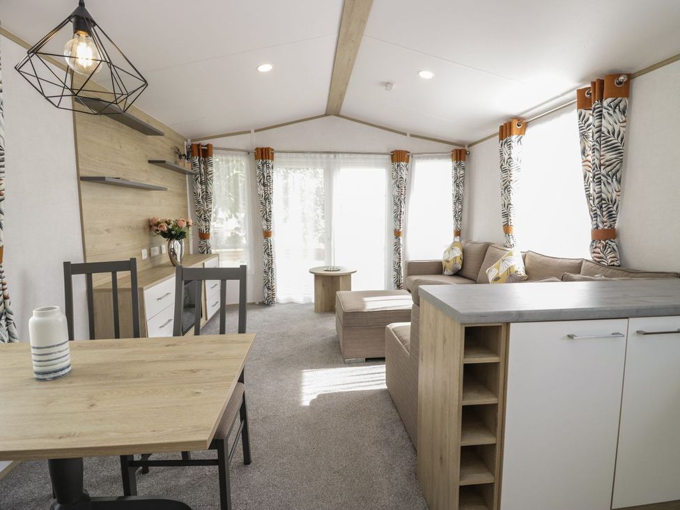 A living room with a sofa and dining area at Ash in Denny