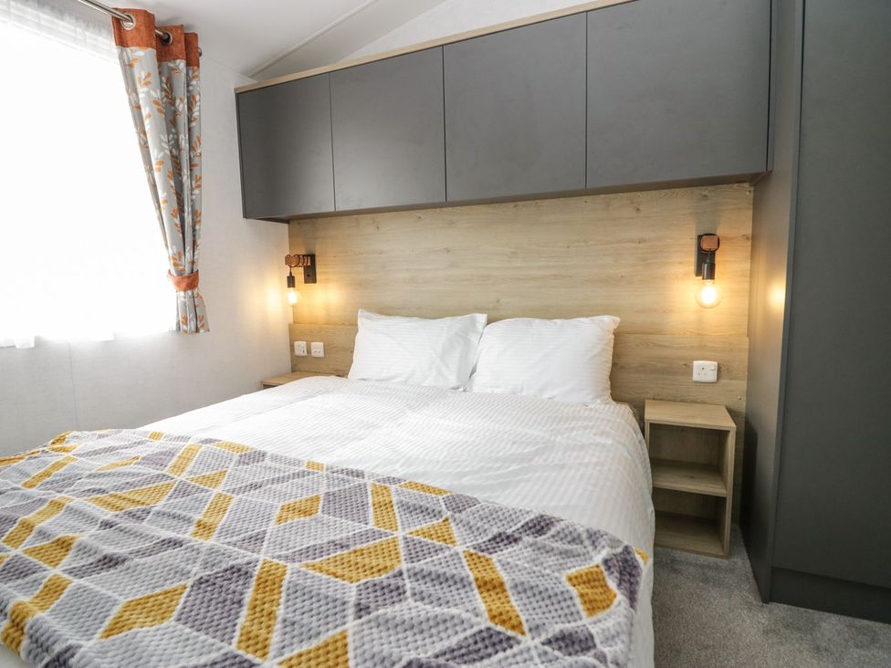 A bedroom with a bed and storage features at Ash in Denny