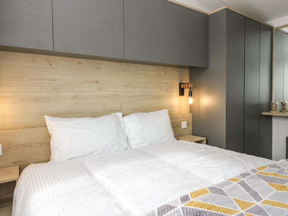 A bedroom with a bed and wall cabinets at Ash in Denny