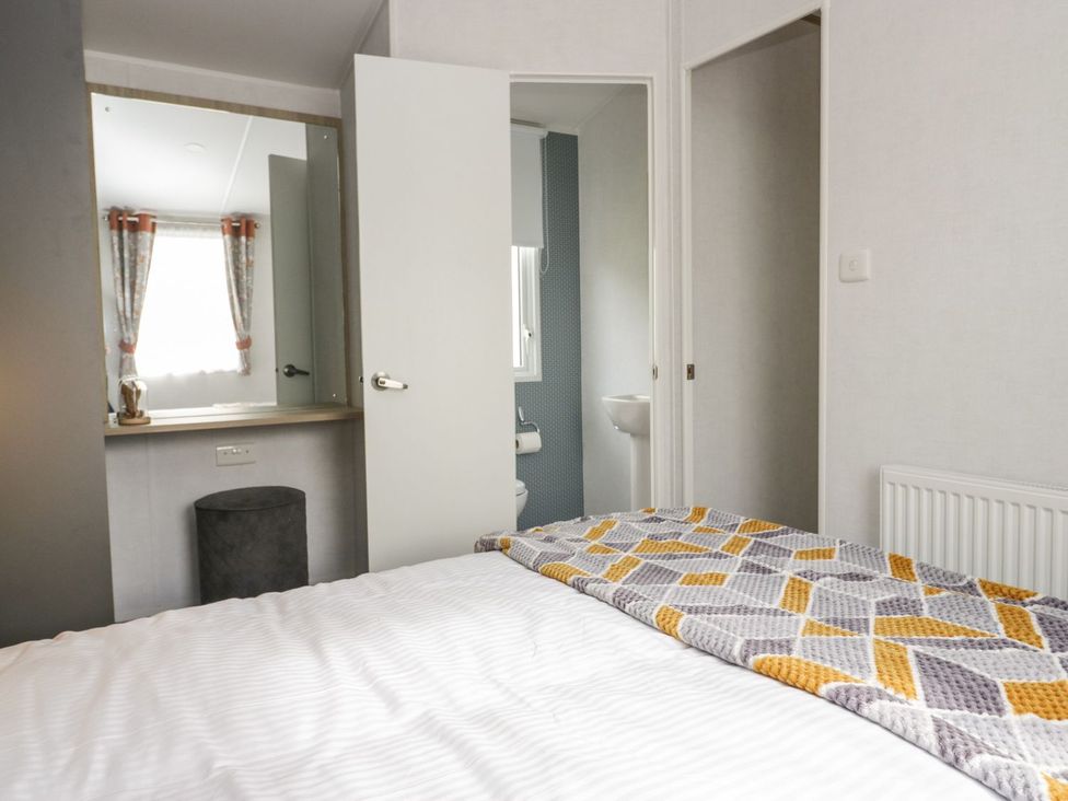 A bedroom with a bed and attached bathroom at Ash in Denny