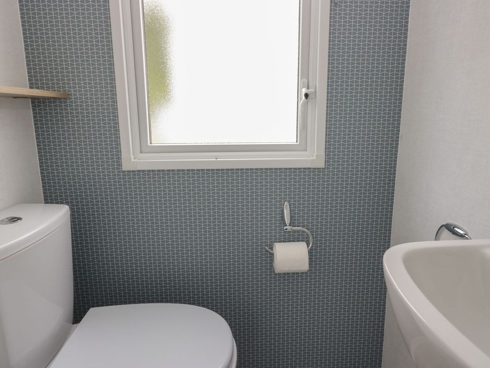 A bathroom with a toilet and sink at Ash in Denny